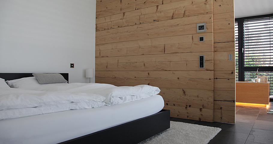 Schlafzimmer mit Wandelementen aus Holz