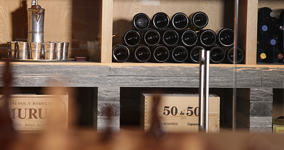 Weinflaschen im Regal aus Holz und Stein